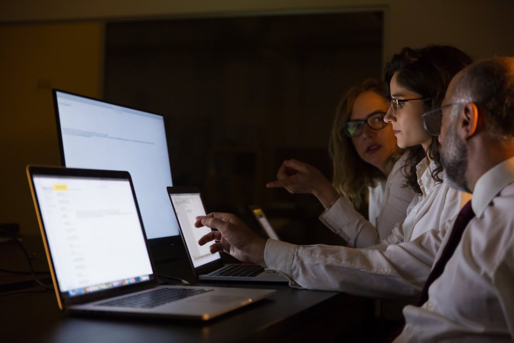 Kvinne sitter med laptop på fanget og ser på kalenderen sin